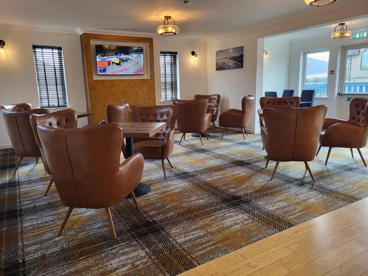 Lounge seating area with chairs and tables at Hamersay Hotel, Lochmaddy